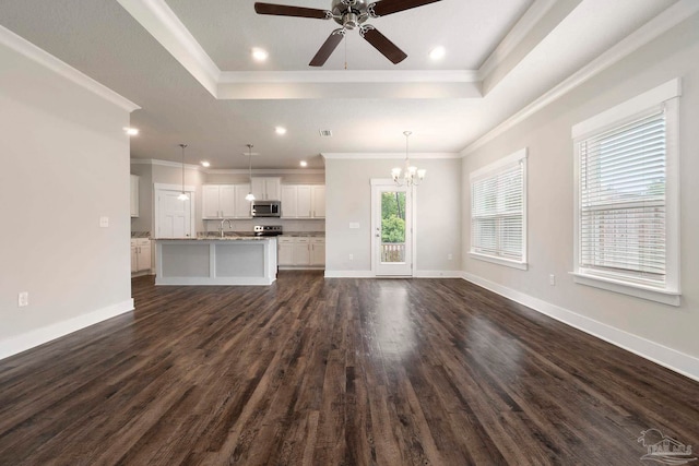 2748 Woodman Loop, Cantonment, FL 32533 - unfurnished living room with a raised ceiling, ceiling fan, a chandelier, dark wood-style floors, and ornamental molding