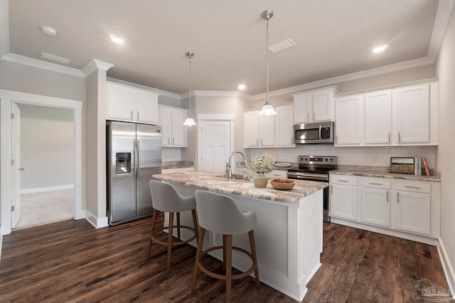 2748 Woodman Loop, Cantonment, FL 32533 - kitchen with stainless steel appliances, ornamental molding, white cabinets, an island with sink, and dark wood finished floors