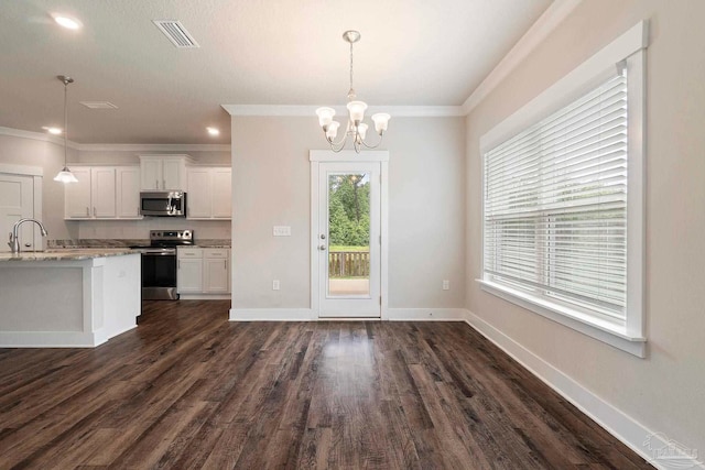 2748 Woodman Loop, Cantonment, FL 32533 - kitchen with appliances with stainless steel finishes, a chandelier, white cabinets, dark wood-type flooring, and hanging light fixtures