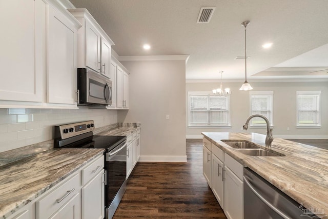 2748 Woodman Loop, Cantonment, FL 32533 - kitchen with appliances with stainless steel finishes, a sink, crown molding, tasteful backsplash, and white cabinetry