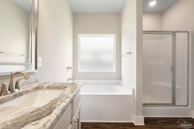 2748 Woodman Loop, Cantonment, FL 32533 - bathroom featuring vanity, a stall shower, a garden tub, and wood finished floors
