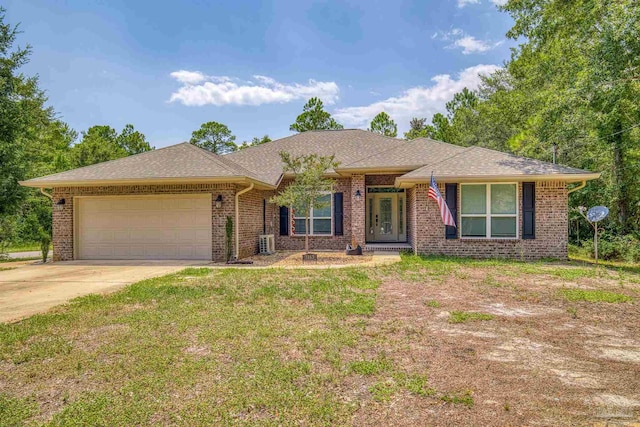 ranch-style home with cooling unit, a garage, and a front yard