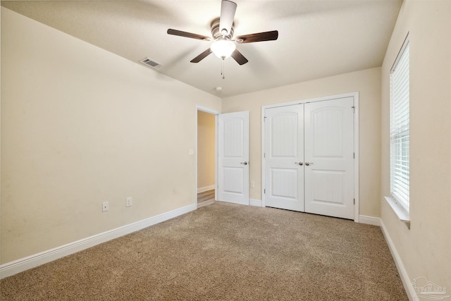 unfurnished bedroom featuring carpet floors, ceiling fan, and a closet