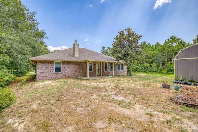 back of property featuring a storage unit