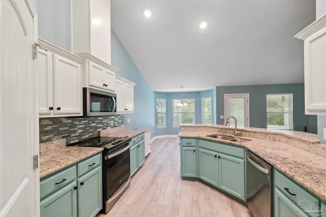 kitchen with decorative backsplash, white cabinetry, appliances with stainless steel finishes, sink, and green cabinets