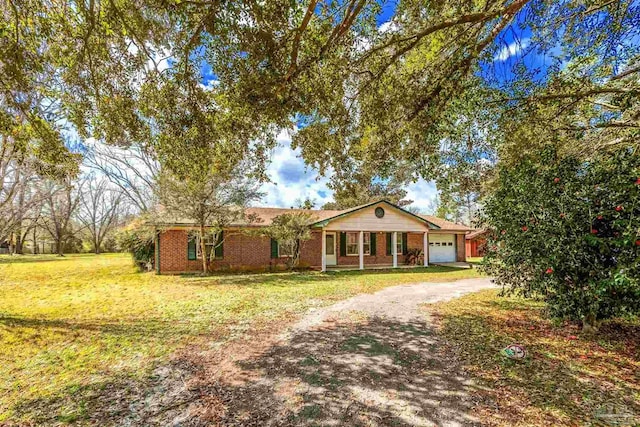 single story home with brick siding, a garage, a front lawn, and driveway