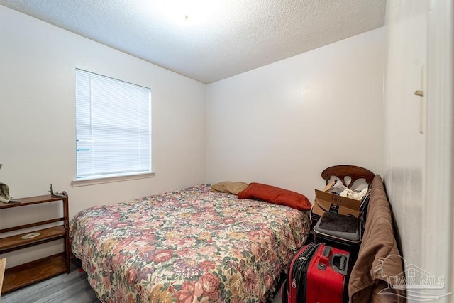 bedroom with light hardwood / wood-style flooring and a textured ceiling