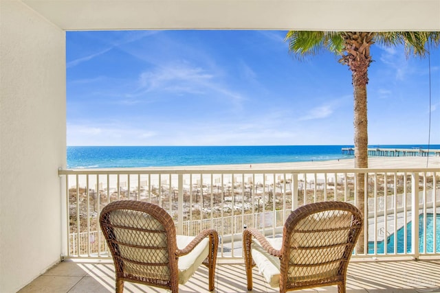 balcony featuring a water view and a view of the beach