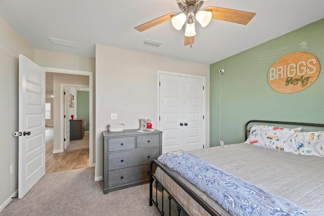 bedroom featuring ceiling fan, a closet, and light colored carpet