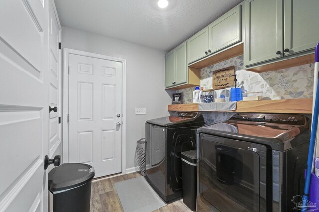 3897 James Stovall St, Pensacola, FL 32526 - clothes washing area featuring cabinet space, washing machine and dryer, light wood finished floors, a textured ceiling, and baseboards