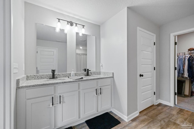 bathroom featuring a textured ceiling, curtained shower, vanity, and hardwood / wood-style flooring