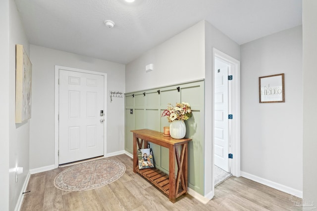 foyer entrance featuring light hardwood / wood-style flooring and a textured ceiling