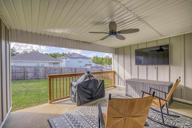 wooden deck with a grill, a patio area, a lawn, and ceiling fan