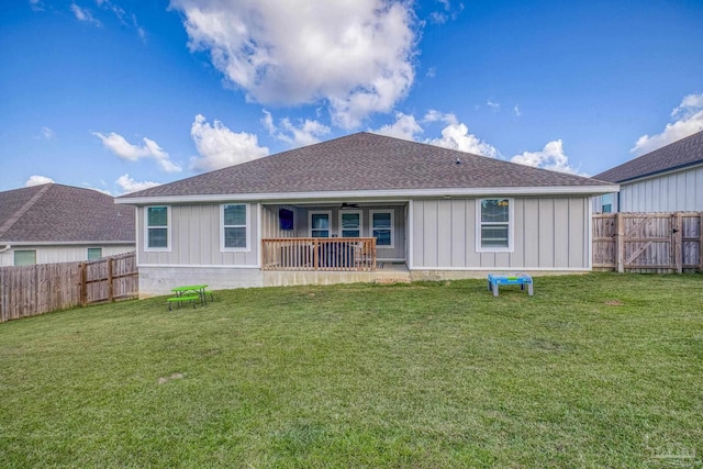 back of property with a lawn and a porch