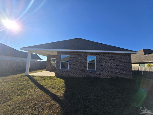 back of property featuring a patio and a lawn