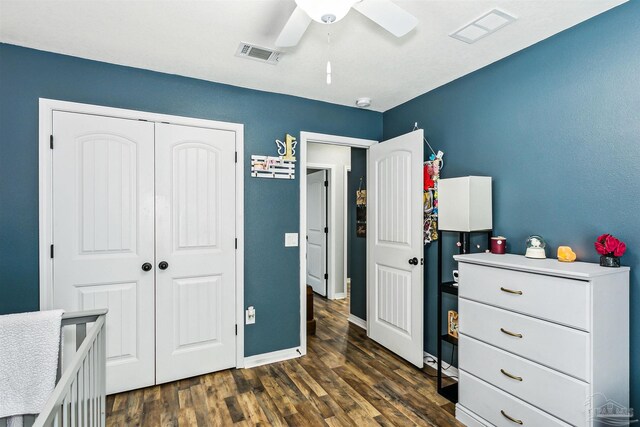 bedroom with ceiling fan, dark wood-type flooring, and a closet