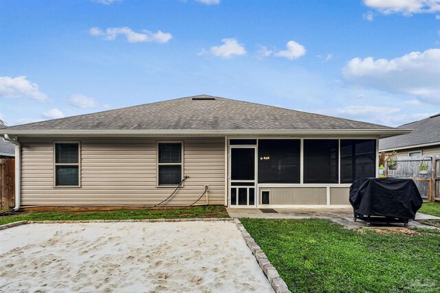 rear view of property with a sunroom, a lawn, and a patio area