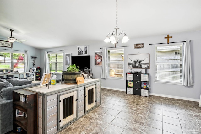 kitchen with a breakfast bar area, lofted ceiling, light tile patterned floors, ceiling fan with notable chandelier, and decorative light fixtures