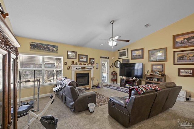 carpeted living room featuring ceiling fan, vaulted ceiling, and a tile fireplace