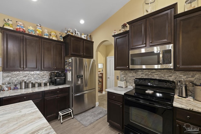 kitchen featuring appliances with stainless steel finishes, dark brown cabinets, and backsplash