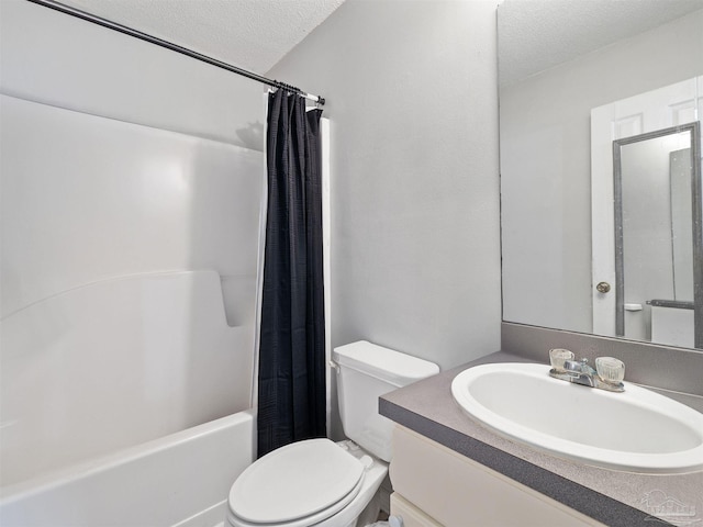 bathroom with vanity, shower / tub combo, toilet, and a textured ceiling