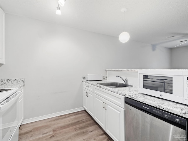 kitchen with baseboards, light wood-style flooring, white appliances, white cabinetry, and a sink