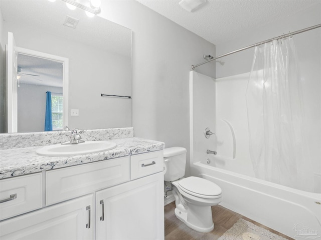 bathroom with visible vents, toilet, a textured ceiling, wood finished floors, and vanity