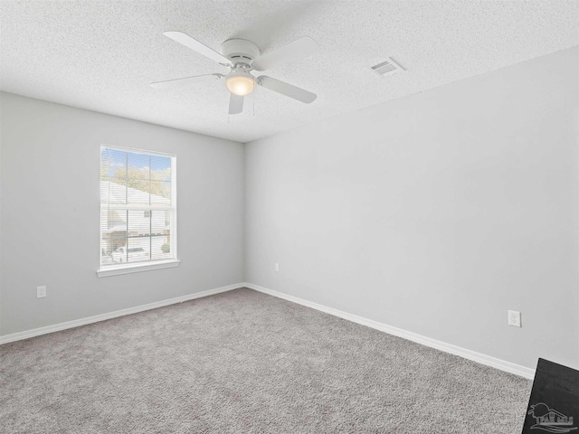 unfurnished room featuring visible vents, a textured ceiling, and ceiling fan