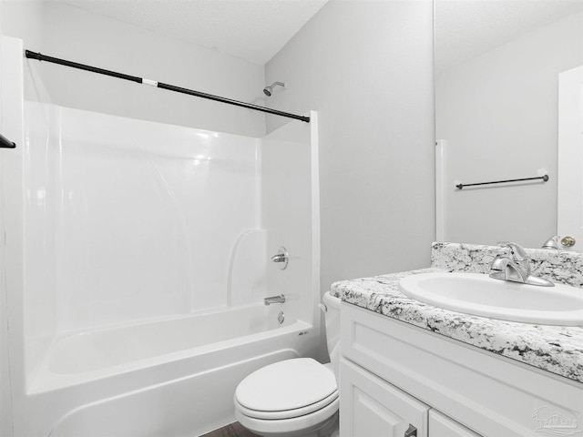 bathroom with a textured ceiling, toilet, vanity, and bathtub / shower combination