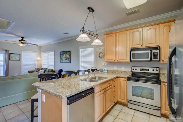 kitchen featuring appliances with stainless steel finishes, pendant lighting, sink, a breakfast bar area, and kitchen peninsula
