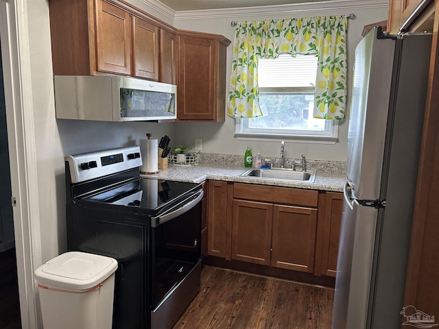 kitchen featuring sink, crown molding, dark hardwood / wood-style floors, stainless steel appliances, and light stone countertops