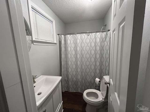 bathroom with sink, wood-type flooring, a textured ceiling, a shower with curtain, and toilet