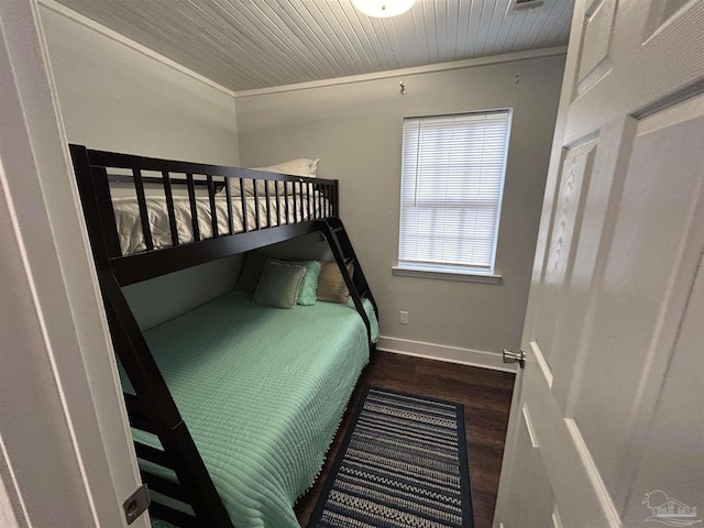 bedroom with ornamental molding, dark hardwood / wood-style floors, and wooden ceiling