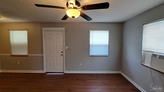 empty room with a textured ceiling and dark wood-type flooring