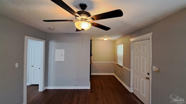 empty room with ceiling fan and dark hardwood / wood-style flooring