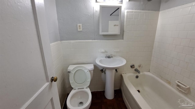 full bathroom with tiled shower / bath combo, toilet, tile walls, and sink