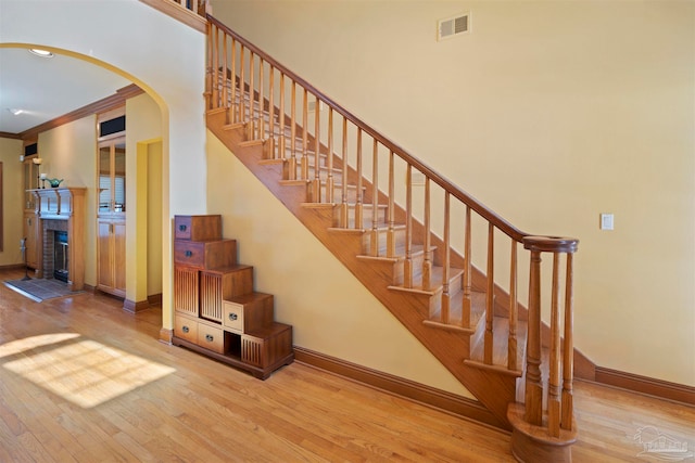 staircase with crown molding and hardwood / wood-style flooring