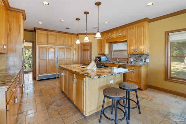 kitchen with decorative backsplash, hanging light fixtures, ornamental molding, a center island, and light stone counters