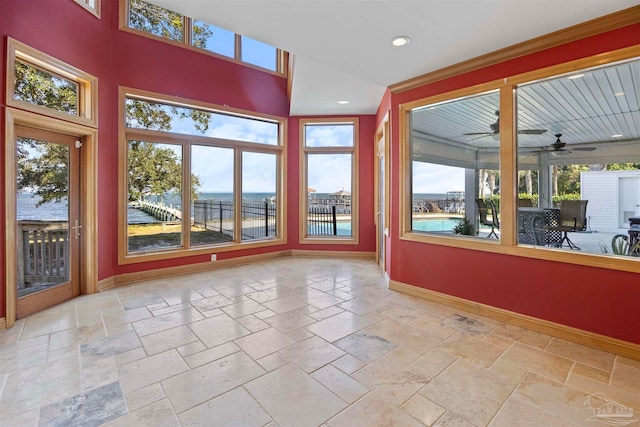 unfurnished sunroom with a water view and ceiling fan