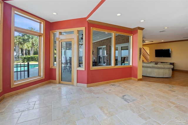 interior space with ornamental molding and ceiling fan