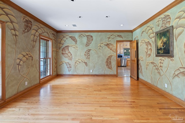 unfurnished room with ornamental molding and light wood-type flooring