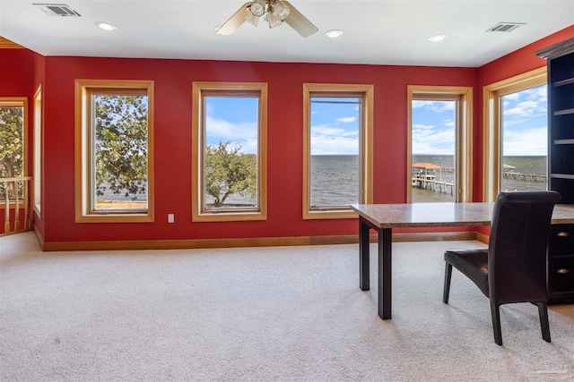 carpeted office featuring a water view and ceiling fan