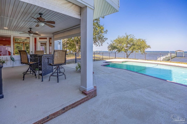 view of swimming pool featuring a water view, ceiling fan, and a patio area