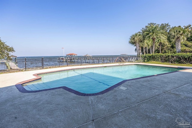 view of swimming pool featuring a patio area and a water view