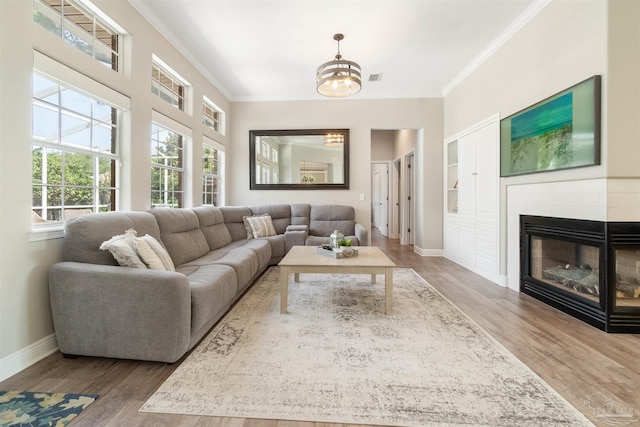 4282 Walden Way, Gulf Breeze, FL 32563 - living room featuring baseboards, a chandelier, crown molding, wood finished floors, and a tile fireplace