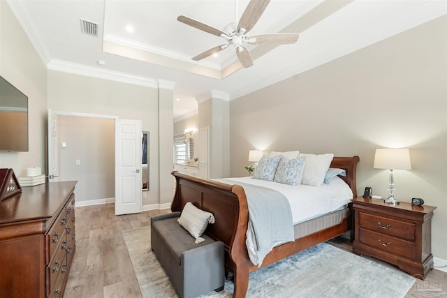 4282 Walden Way, Gulf Breeze, FL 32563 - bedroom featuring light wood-style flooring, crown molding, a tray ceiling, a ceiling fan, and ensuite bath