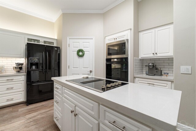 4282 Walden Way, Gulf Breeze, FL 32563 - kitchen with black appliances, decorative backsplash, ornamental molding, white cabinetry, and light wood-style floors