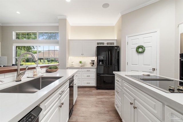 4282 Walden Way, Gulf Breeze, FL 32563 - kitchen featuring black appliances, a sink, ornamental molding, light wood finished floors, and tasteful backsplash