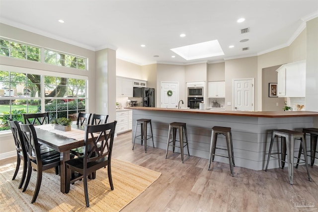 4282 Walden Way, Gulf Breeze, FL 32563 - dining area featuring a skylight, ornamental molding, light wood-type flooring, and recessed lighting