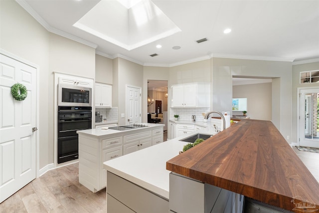 4282 Walden Way, Gulf Breeze, FL 32563 - kitchen featuring a kitchen island with sink, stainless steel microwave, a sink, tasteful backsplash, and ornamental molding